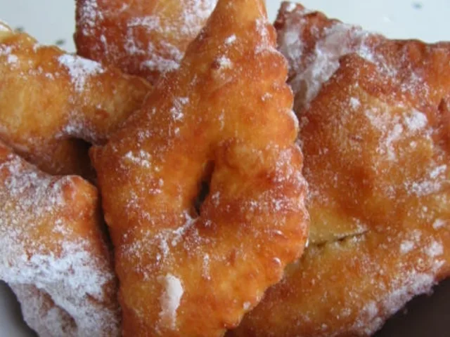 Bugnes lyonnaises dorées saupoudrées de sucre glace